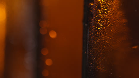 Ziehen-Sie-Den-Fokus,-Nahaufnahme-Von-Kondensationstropfen-Auf-Flaschen-Mit-Kaltem-Bier-Oder-Alkoholfreien-Getränken